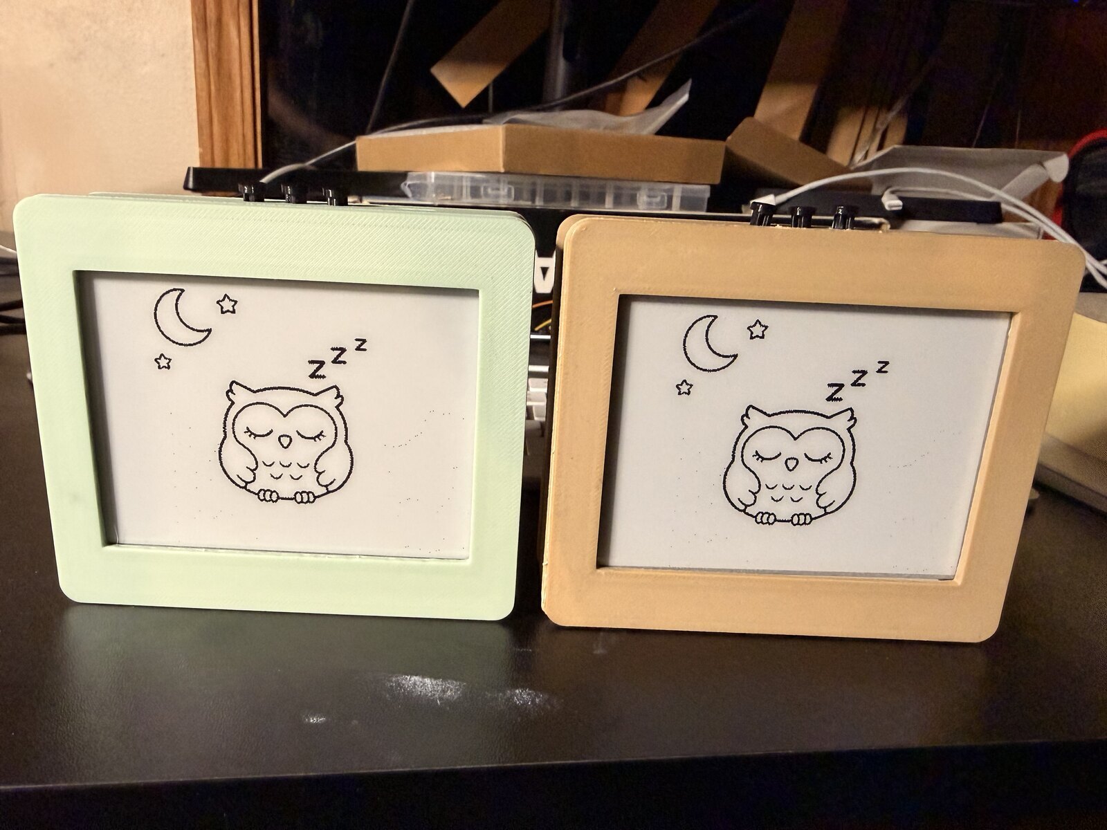 Two early 3D-printed cases in pale green and yellow, both displaying a sleeping owl